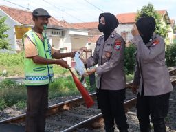 Polwan Berbagi Daging Kurban di Perlintasan Kereta Api 