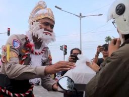 Berkostum Wayang Polisi Bagikan Takjil di Simpang Empat Sirandu