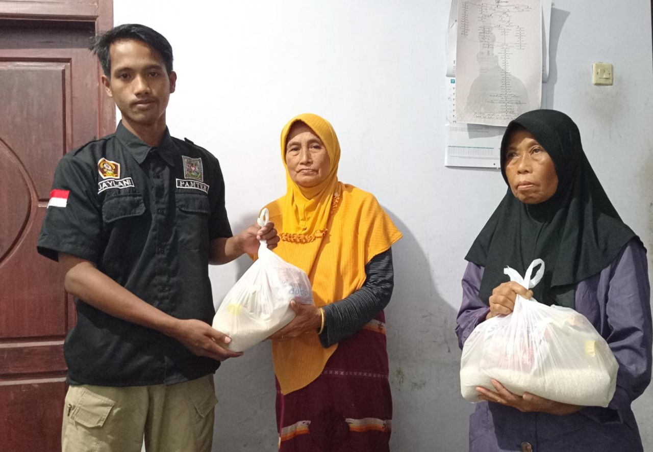 Salah satu koordinator pembagian sembako PSHT Ranting Binakal, saat membagikan pada penerima