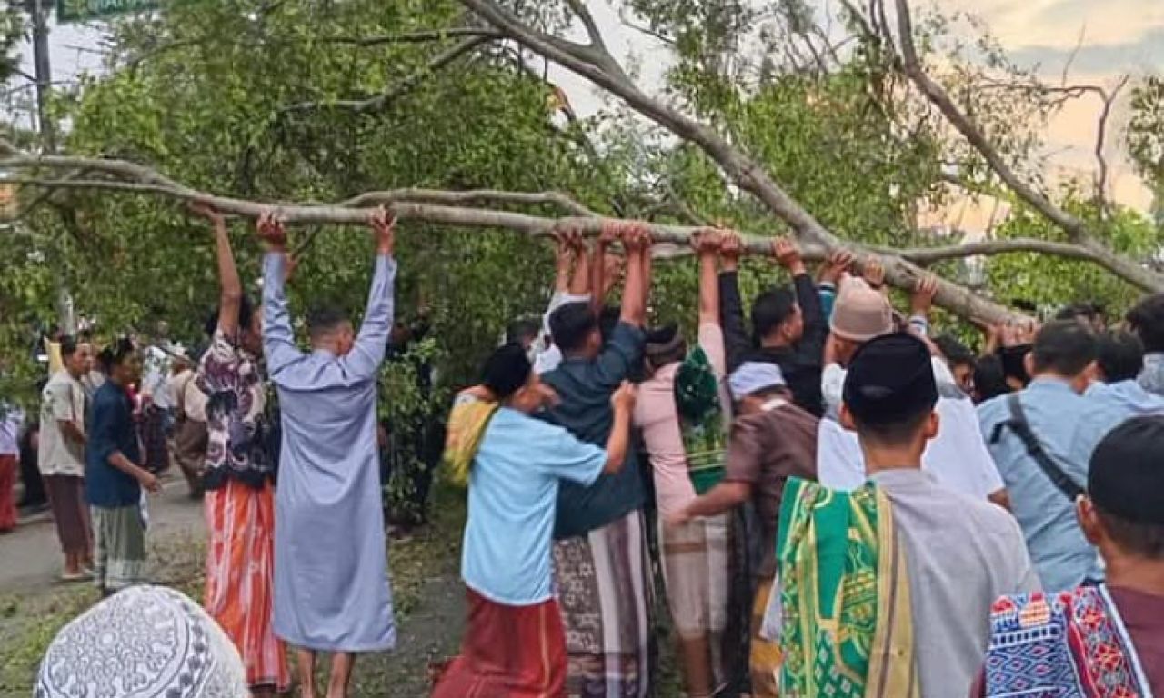Jamaah saat gotong royong membersihkan ranting pohon beringin yang roboh