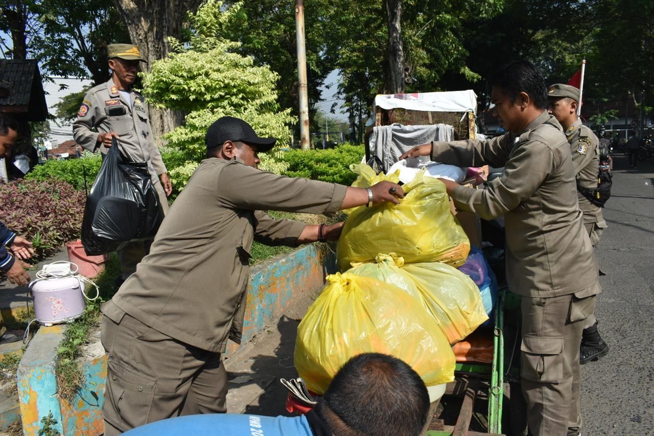 Satpol PP saat membersihkan barang-barang di dalam toilet umum