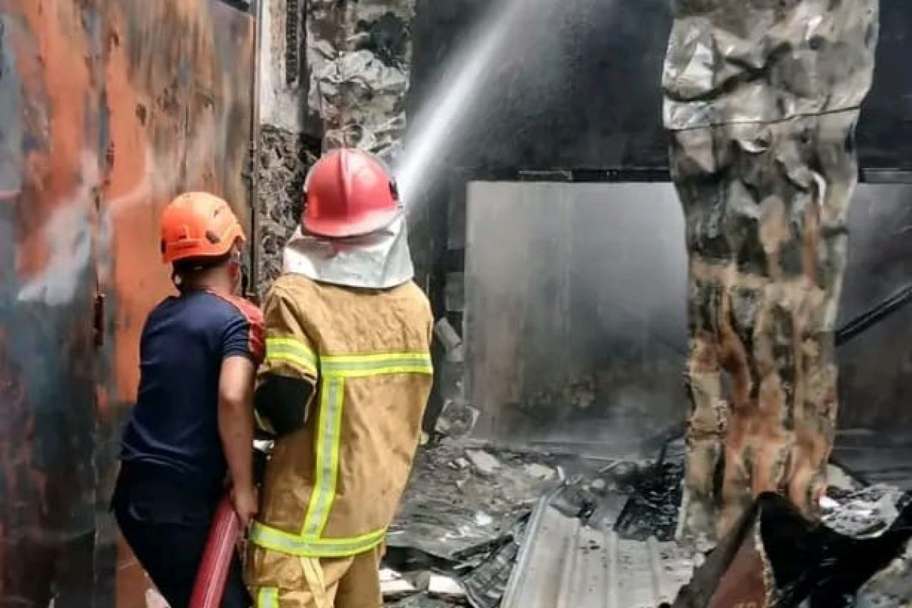 Damkar saat memandang api yang melalap bengkel motor