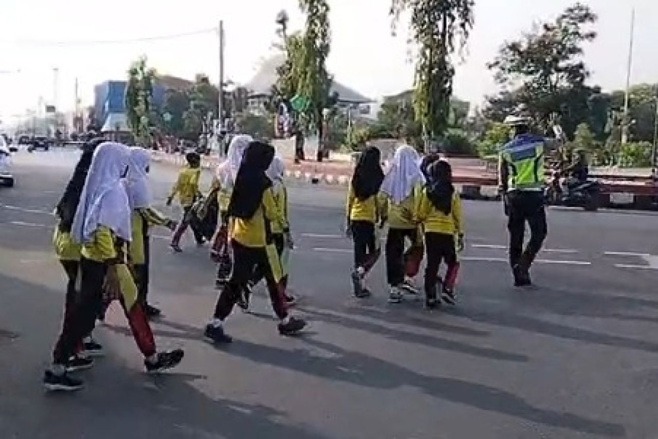 Personil Satlantas Polres Pemalang membantu anak-anak menyeberang jalan